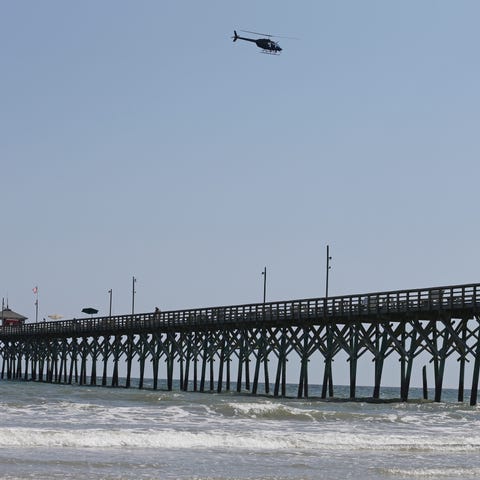 A helicopter flies over the Ocean Crest Pier in...