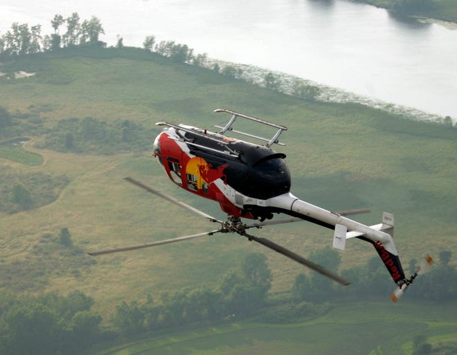 Chuck Aaron does a roll with Red Bull's BO-105 CBS helicopter over Lake Buttes des Mortes near Oshkosh, Wisconsin, while performing at the 2008 Experimental Aircraft Association Convention.