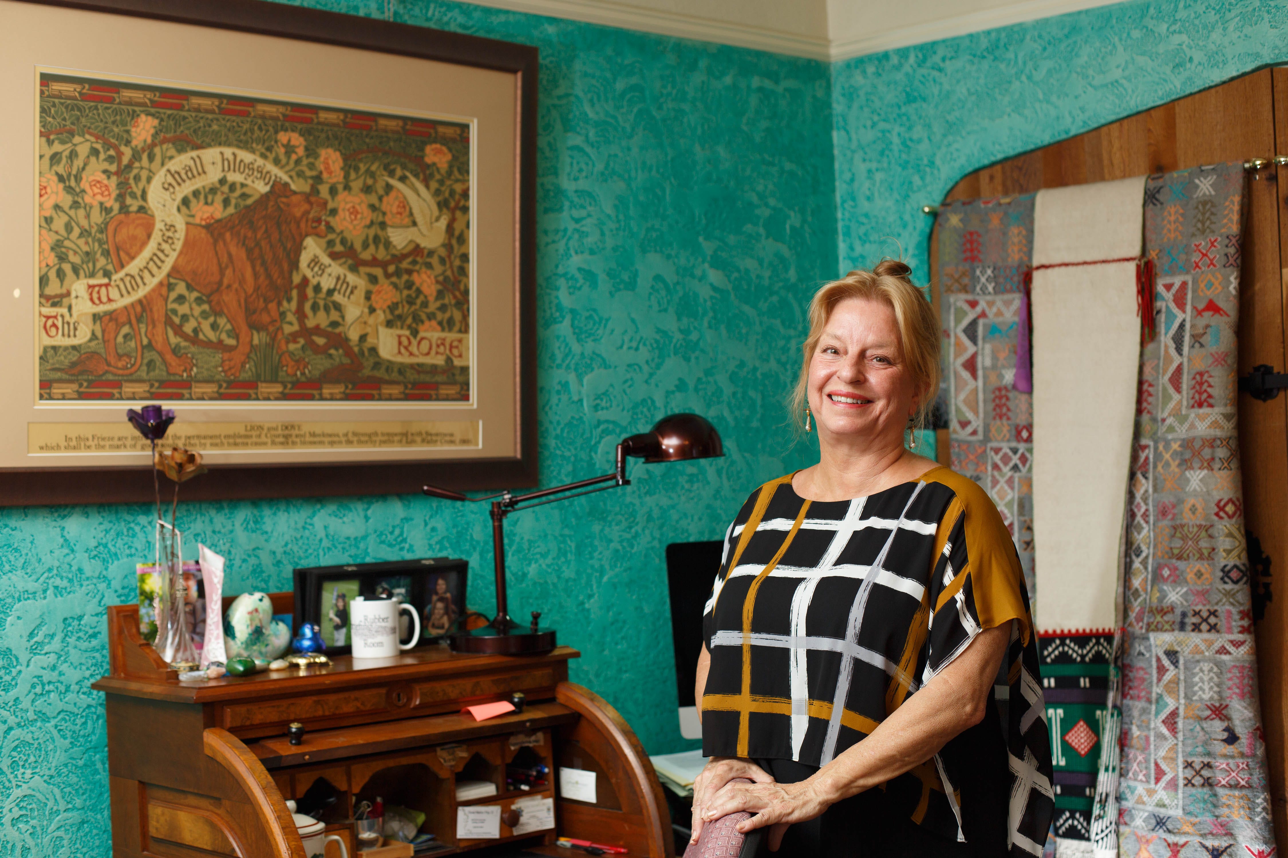 Marilyn Wooley, a Redding therapist, stands by a frieze in her office that gives her inspiration after the Carr Fire.