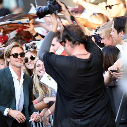 US actor Brad Pitt poses with fans as he arrives...