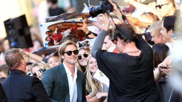 US actor Brad Pitt poses with fans as he arrives...