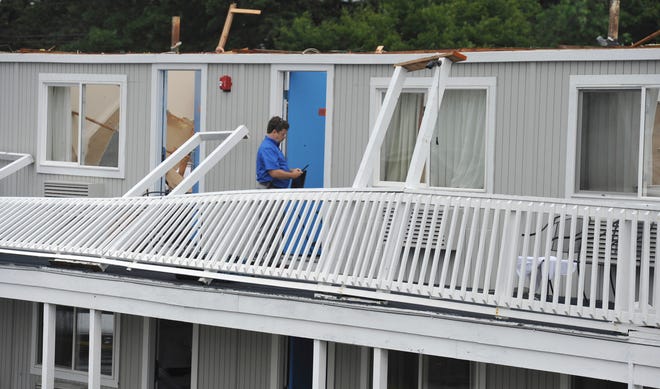 A Yarmouth building department worker surveys the damage to the second floor of the Cape Sands Inn where a tornado touched down ripping off the second floor of the structure, Tuesday, July 23, 2019, in West Yarmouth, Mass.
