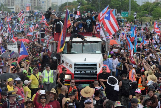 Puerto Rican singer Ricky Martin, front atop truck, participates with other local celebrities in the protest.