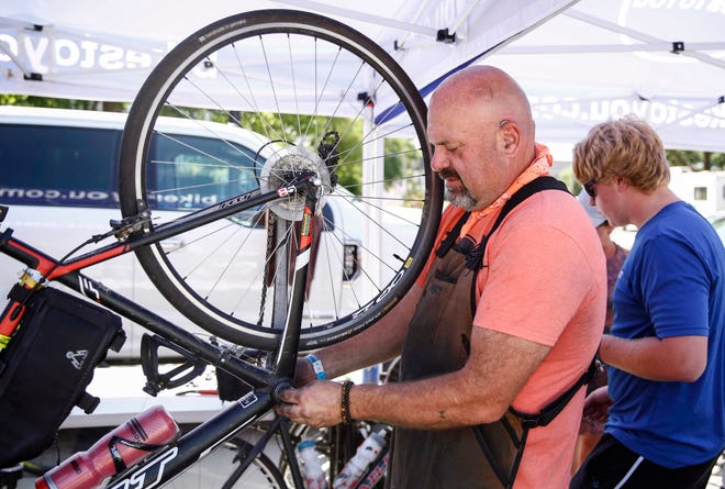 Bike mechanic Craig Cooper of Bikes To You in Grinnell makes repairs to a bicycle in Indianola during RAGBRAI in 2019.