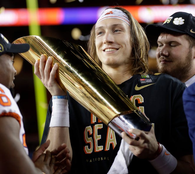 Trevor Lawrence holds the trophy after Clemson beat Alabama in the College Football Playoff championship game last season.