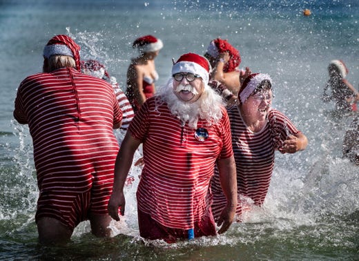 Participants in the World Santa Claus Congress have their annual saltwater foot bath at Bellevue Beach, at Bakken, north of Copenhagen, Denmark, July 23, 2019.
