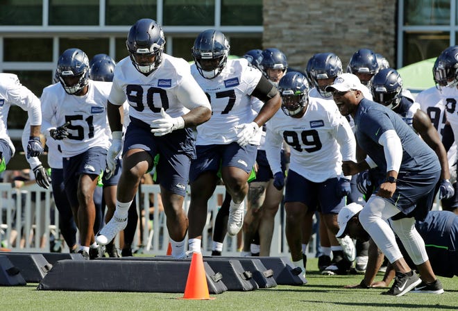 Seattle Seahawks defensive tackle Jarran Reed (90) runs a drill with teammates during NFL football training camp, Thursday, July 25, 2019, in Renton, Wash.