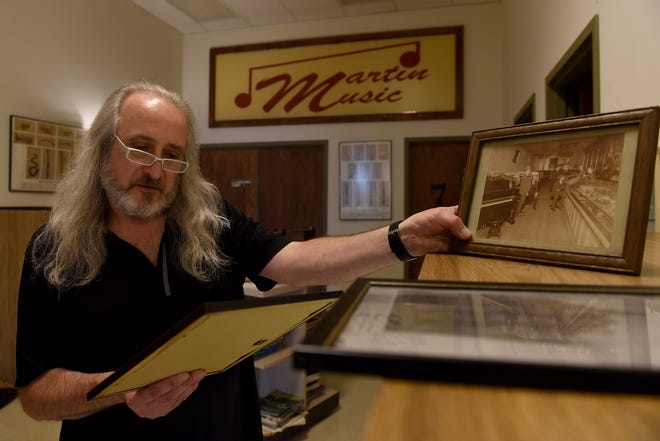 President and CEO Doug Baker shows photos and newspaper articles from throughout Martin Music's 71 year history selling and repairing instruments, musical equipment and hosting music lessons in Newark.