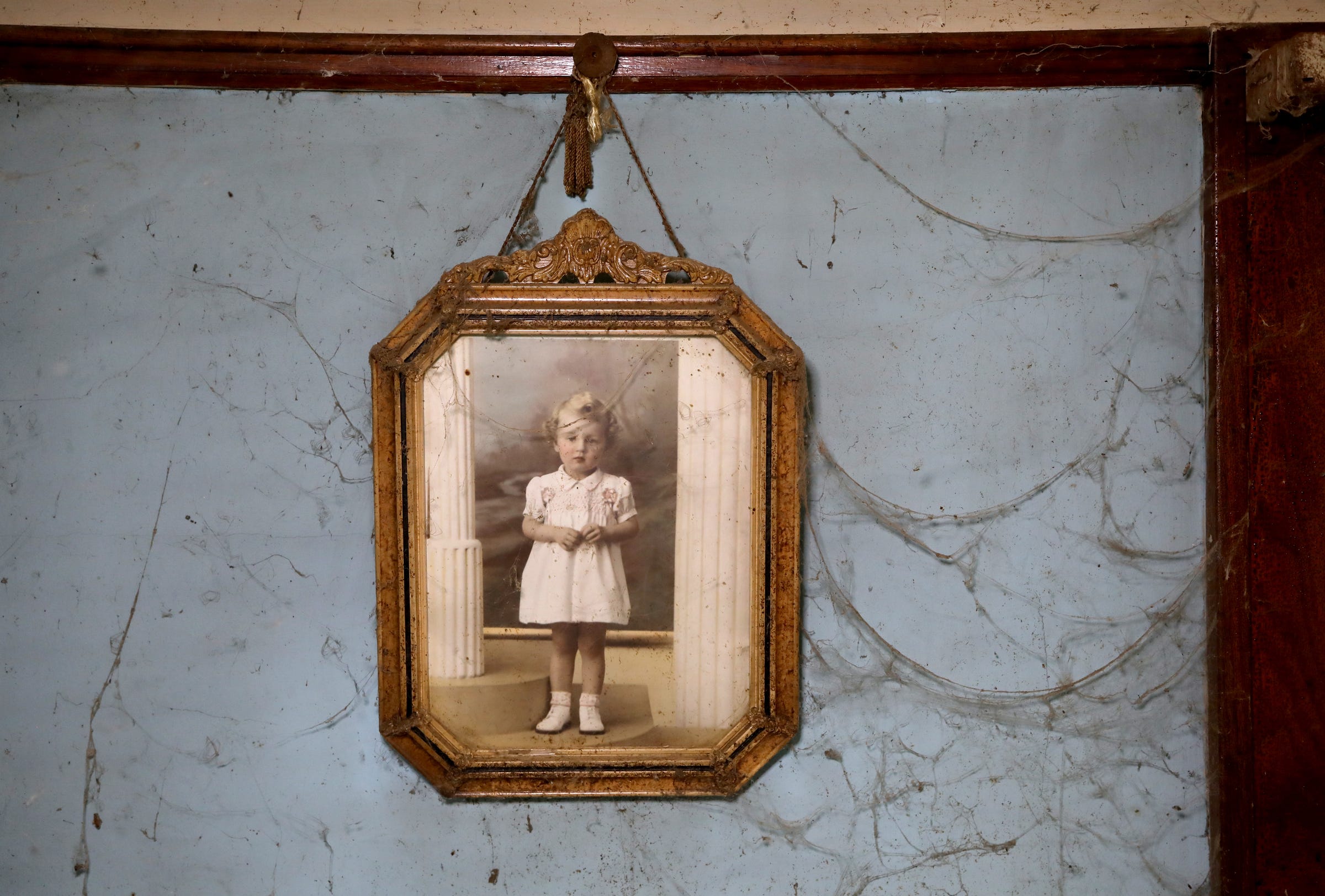 Surrounded by cobwebs from years of not being cleaned, a picture of Sally Honeycheck, taken back in the 1930's, has hung on the walls for decades in the house she shared with her sister Lorraine Honeycheck in Detroit, Michigan as seen on Sunday, June 23, 2019. The sisters lived in squalor for decades and Sally, alone in the house, died in mid to late November 2018.