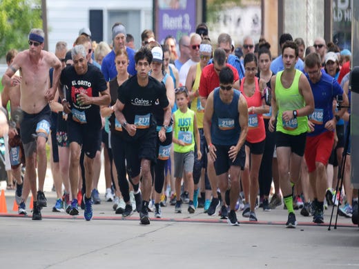 Runners take off during the start of the Two Rivers Brew Dash 5k run/walk, Saturday, July 27, 2019, in Two Rivers, Wis.