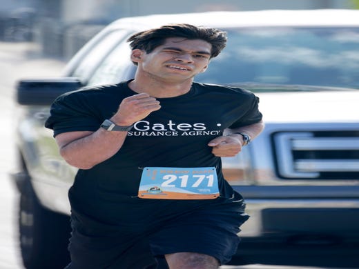 Benjamin Weina (2171) grimaces while in the lead during the Two Rivers Brew Dash 5k run/walk, Saturday, July 27, 2019, in Two Rivers, Wis. Weina came in first for men at the event.