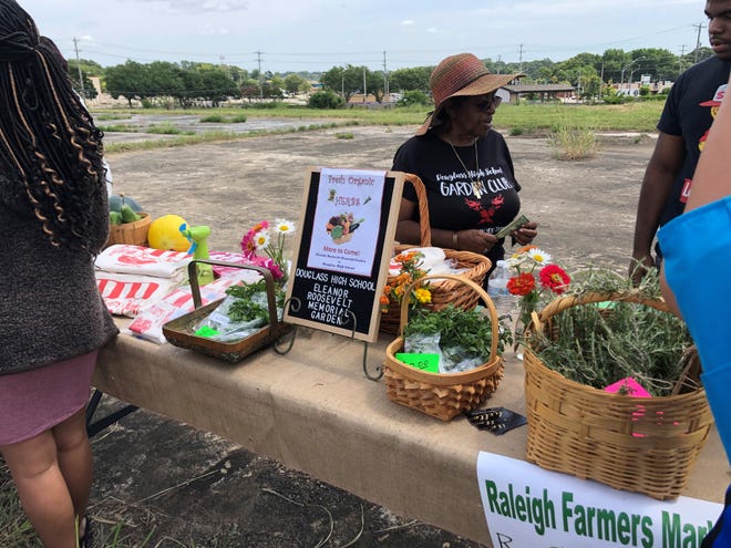 Local vendors sell items during an event unveiling plans for a farmers market and community center in Raleigh.