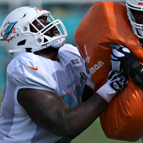 Miami Dolphins dffensive linemen engage in...