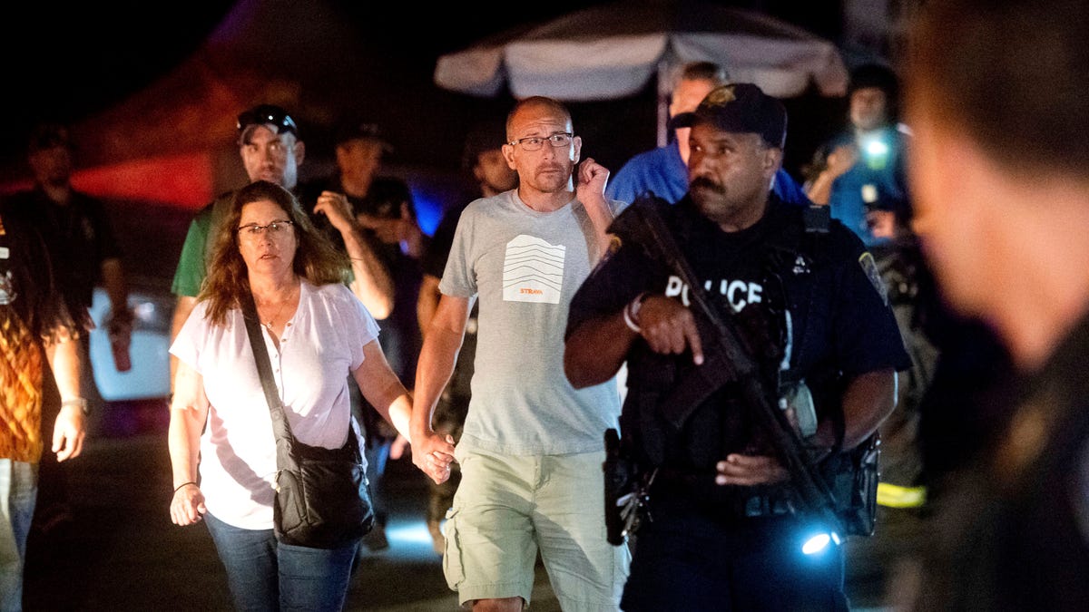 Police officers escort people from Christmas Hill Park following a deadly shooting during the Gilroy Garlic Festival, in Gilroy, Calif., on Sunday, July 28, 2019.
