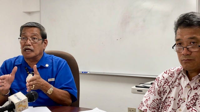 Sen. Joe San Agustin, left, goes over the details of his fiscal 2020 budget bill, while Office of Finance and Budget Director Stephen Guerrero, right, looks on, at a news briefing on July 30, 2019 in Tamuning.