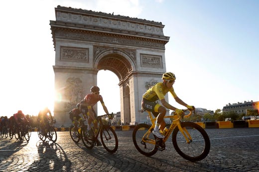 Colombia's Egan Bernal wearing the overall leader's yellow jersey, center, rides past the Arc de Triomphe on the Champs-Elysees during the twenty-first stage of the Tour de France cycling race over 79 miles with start in Rambouillet and finish in Paris, France, July 28, 2019.