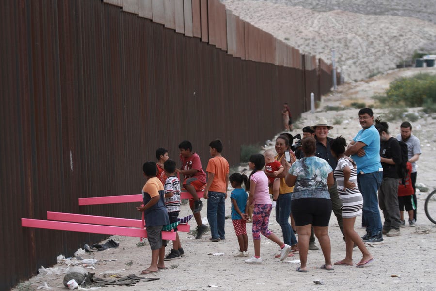 Children in Juarez, Mexico, play on a seesaw installed at the border fence that divides Mexico from the USA on July 28.