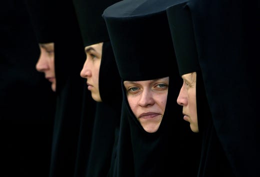 Orthodox nuns look on as they take part in a religious procession during the celebration of the 1031st anniversary of the Christianisation of Kievan Rus in Kiev on July 27, 2019.