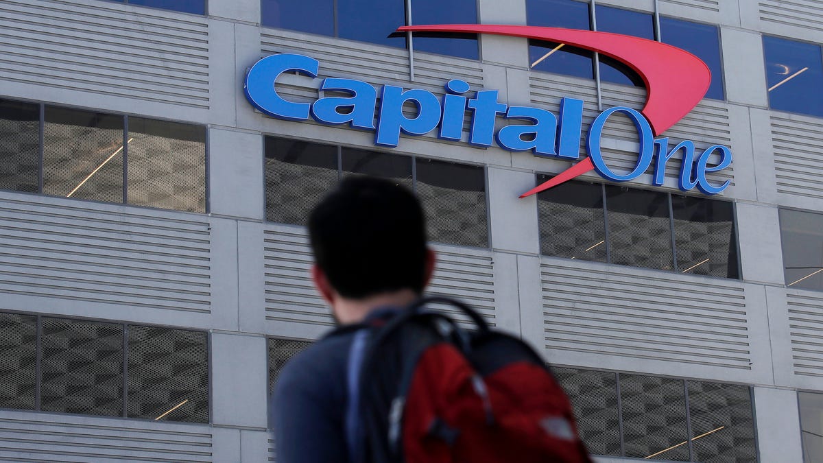 In this July 16, 2019, photo, a man walks across the street from a Capital One location in San Francisco.