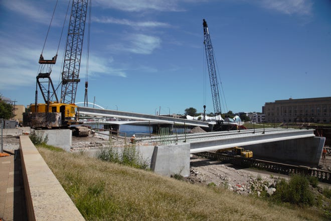 Workers on Tuesday, July 30, 2019, installed the first support beams for the Locust Street bridge in downtown Des Moines. The project was delayed by high water, which will push back its opening until next summer.