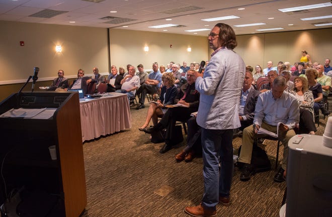 Officials present the project plans for a downtown apartment complex along the White River Tuesday night at the Horizon Convention Center. The developer of the project will go before city council on Aug. 5 for final economic agreement approvals.