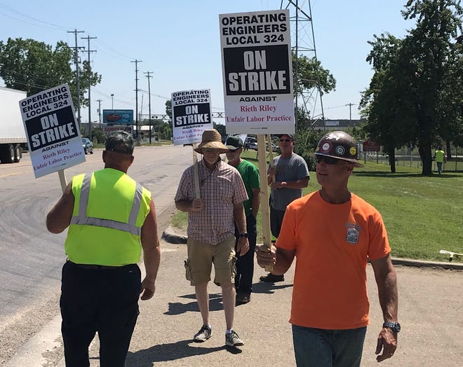 Kevin Zimmerman, right, member of Operating Engineers Local 324, Roger Henfling, middle, worker at Rieth-Riley Construction Company, and others picket outside the Lansing Rieth-Riley facility Thursday. Workers began the strike at 12 a.m. Thursday, protesting labor practices and lack of a contract.
