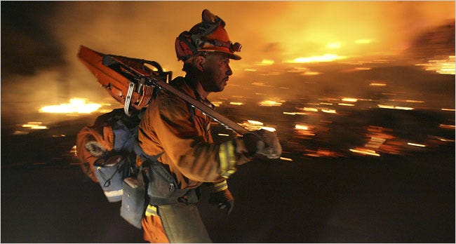 A firefighter walked along a back fire on a hillside in Jamul, Calif. during the 2007 Harris Fire.