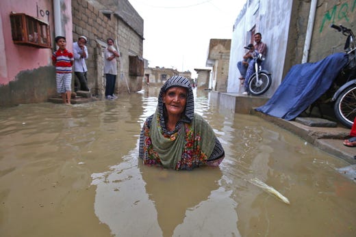 People make their way through a flooded road during heavy monsoon rains in Karachi, Pakistan on July 30, 2019. Floods and landslides are common occurrences during South Asia's monsoon season between July and September, and lead to casualties as well as significant material damages.