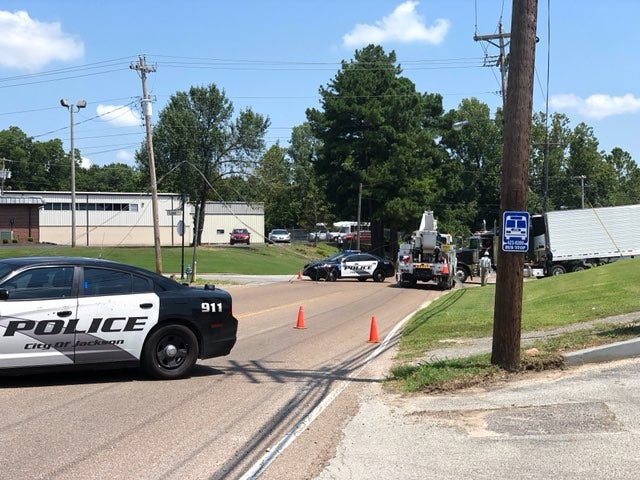 Jackson Police vehicles block the roadway near the intersection of Whitehall Street and Lifsey Drive in Jackson, Tenn., where a tractor trailer downed a line on Aug. 2.