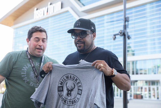 Rapper and Big 3 founder Ice Cube receives a Milwaukee Bucks t-shirt from the Bucks president Peter Feigin.