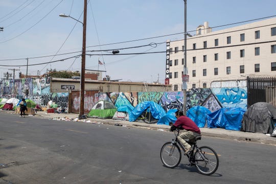 Homeless people and their tents line a Skid Row street on Friday, May 31, 2019, in downtown Los Angeles.