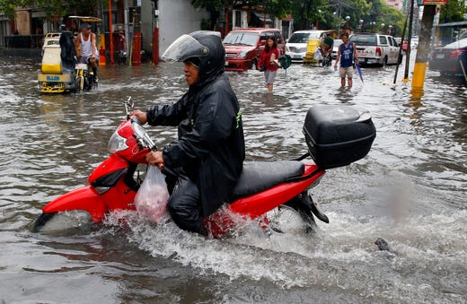 Motorists maneuver their vehicles through a flooded street following heavy downpour overnight that inundated low-lying areas in the metropolis on Aug. 2, 2019 in Manila, Philippines.