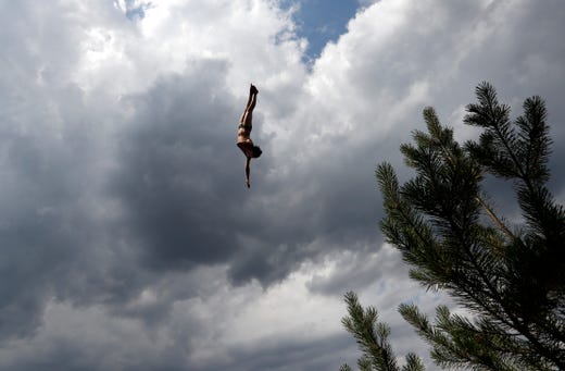 A competitor jumps into water during a high diving competition near the village of Hrimezdice, Czech Republic on Aug. 2, 2019.