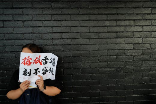 A woman holds up a sign that reads: "Rescue Hong Kong, There is no time for delay" during a demonstration in Hong Kong on Aug. 2, 2019. Two demonstrations by civil servants and workers in the medical and health care sector were also planned for Friday evening.