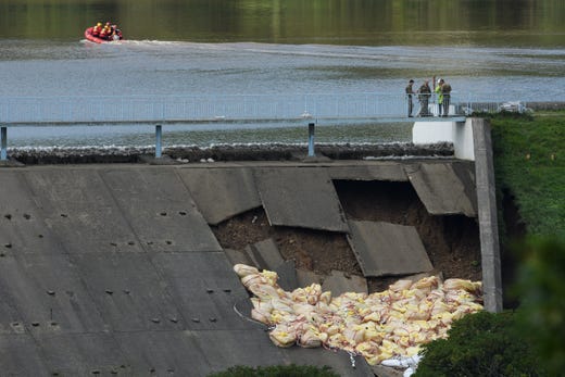 Members of the emergency services check the positioning of sandbags after they were dropped onto the dam wall at Toddbrook reservoir following a severe structural failure after heavy rain, on August 02, 2019 in Whaley Bridge, England.