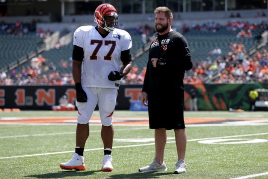 Cincinnati Bengals offensive tackle Cordy Glenn (77) talks with injured offensive tackle Jonah Williams, right, during Cincinnati Bengals training camp practice, Saturday, Aug. 3, 2019, at the practice fields next to Paul Brown Stadium in Cincinnati.