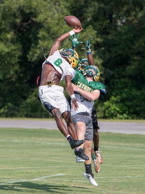 Damarius McGhee (6) leaps to break up a pass during football practice at Pensacola Catholic High School in Pensacola on Wednesday, July 31, 2019.