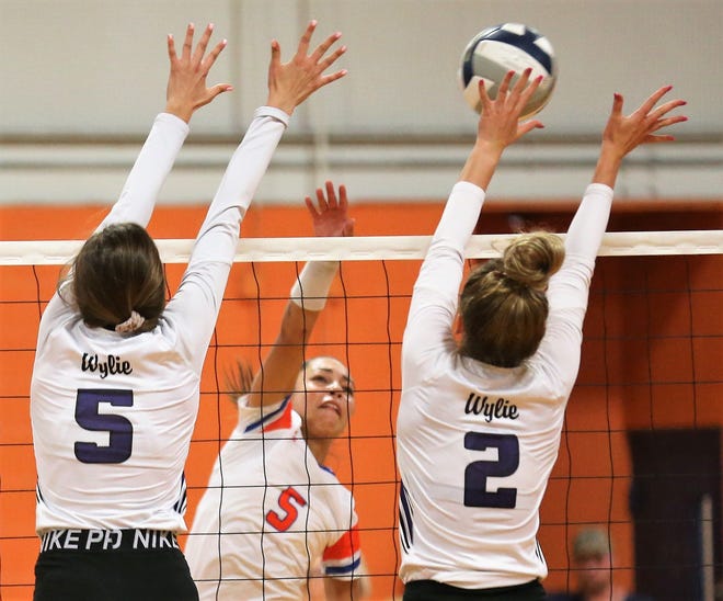 San Angelo Central's Mya Moore (background) tries to drive the ball past Abilene Wylie's Lilly Kate Doby (5) and Avery Wimberly during the volleyball season opener at Central's Trevino gym on Tuesday, Aug. 6, 2019.