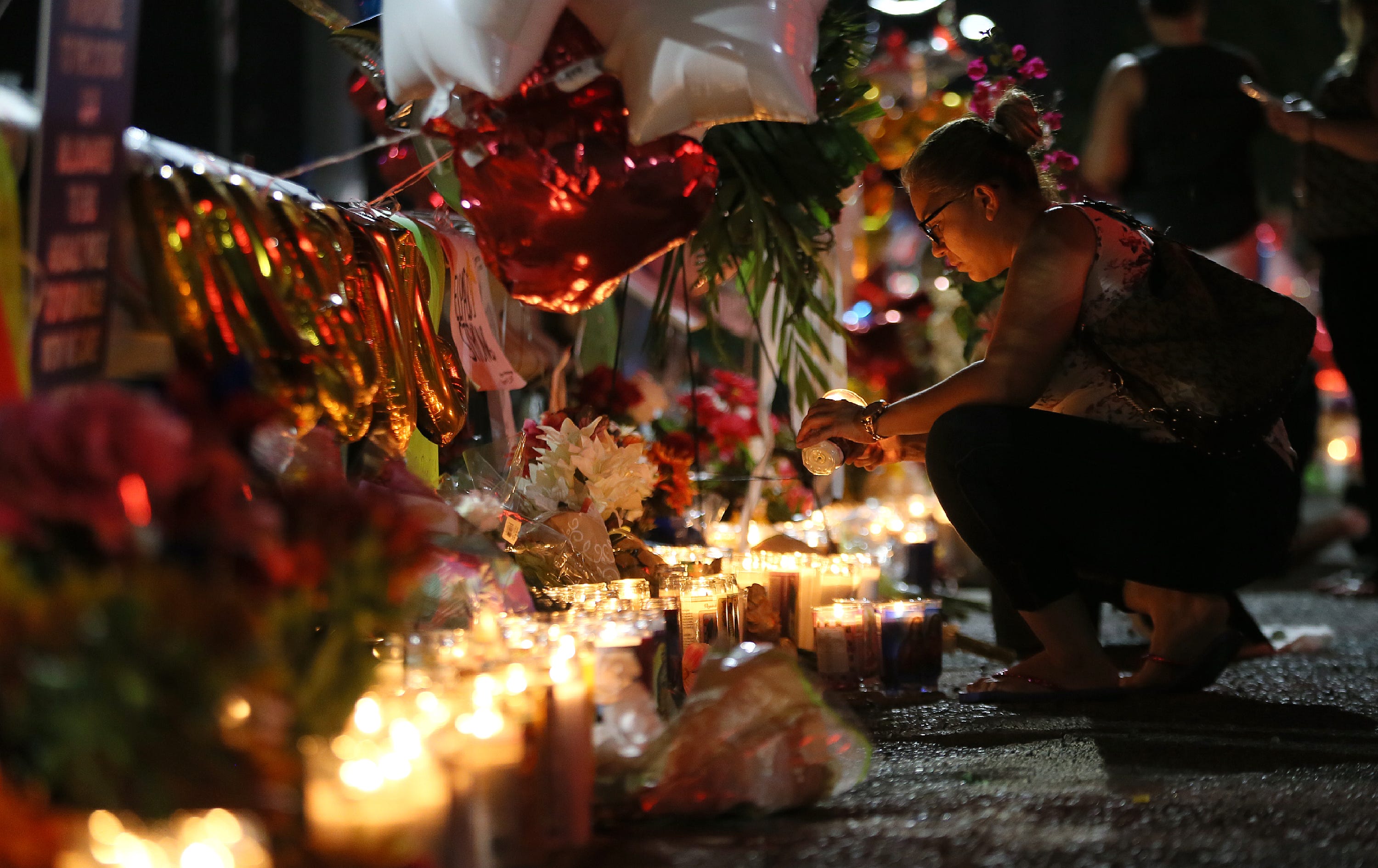 El Pasoan Roxana Jaquez lights a candle at a makeshift memorial on Monday, August, 5, 2019, outside the Walmart in El Paso, Texas. The racism-fueled mass shooting of Aug. 3, 2019, would become the deadliest attack on Hispanics in modern U.S. history, ultimately taking 23 lives.