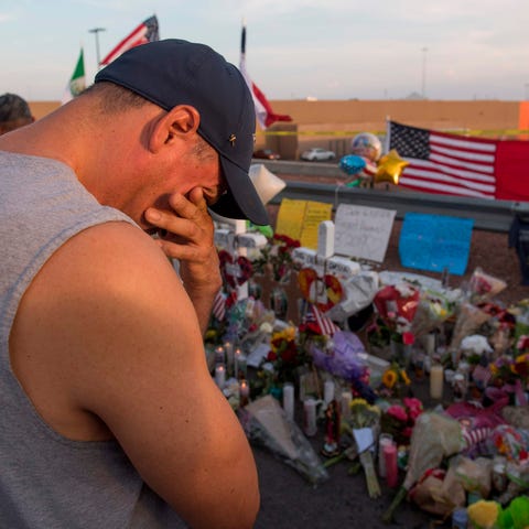 A man prays at a makeshift memorial for victims...