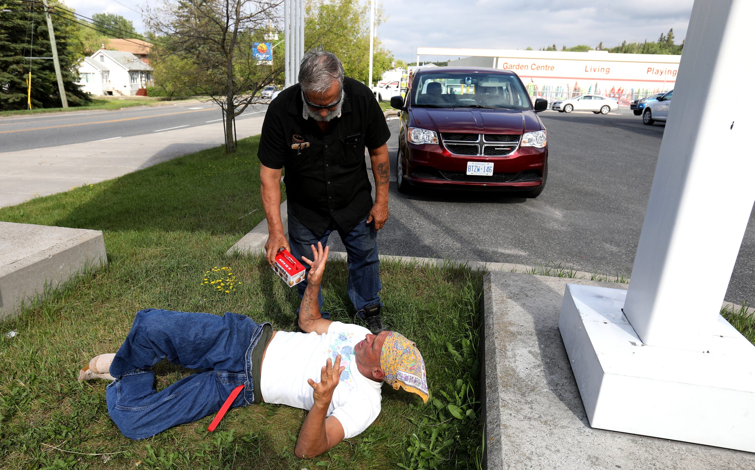 Joe Murphy often returns to sleep underneath the Canadian Tire gas station sign where many residents of Kenora, Ontario, are used to seeing him. Often, people stop by, bringing him food from McDonalds and Tim Hortons like this man did for him on Wednesday, July 10, 2019. After living in a hotel in Kenora, Ontario, Canada set up by former NHL hockey players, former Detroit Red Wings player Joe Murphy is back on the streets of that city and homeless.