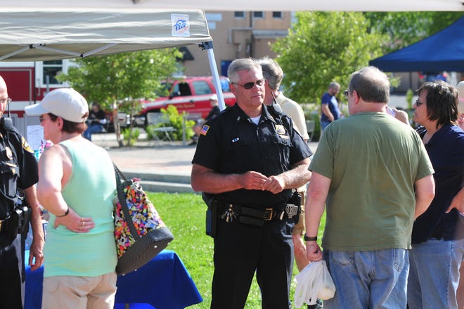 Visitors to the Tuesday Twilight Market at Elstro Plaza visit with Richmond Police Department Lt. Donnie Benedict for RPD's National Night Out.