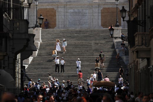 People walk down the Spanish Steps, in Rome on Aug. 7, 2019. Police started the enforcement of a law designed to protect monuments and landmarks and are forbidding people from sitting on the Spanish steps since they are considered a monument.