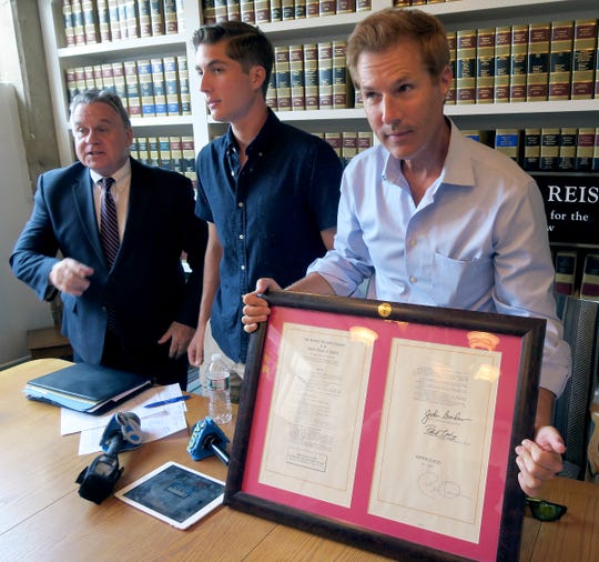 On the 5th Anniversary of its signing, David Goldman is joined by his son Sean as he holds a copy of the Sean and David Goldman International Child Abduction Prevention and Return Act during a news conference in Red Bank Thursday, August 8, 2019. It was spearheaded by US Congressman Chris Smith shown at left.