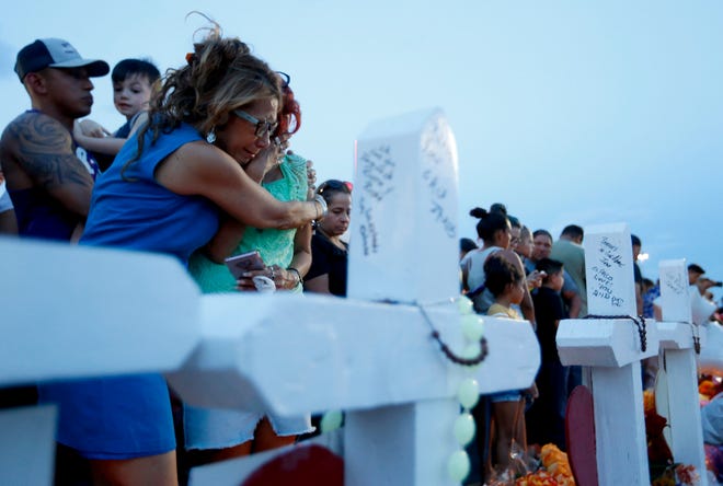 Rebecca Najera, left, hugs Elsa Escobar as they joined others gathered Monday, Aug. 5, 2019 in front of crosses representing the victims who died in the shooting at a Walmart in El Paso, Texas. (Vernon Bryant/The Dallas Morning News/TNS)