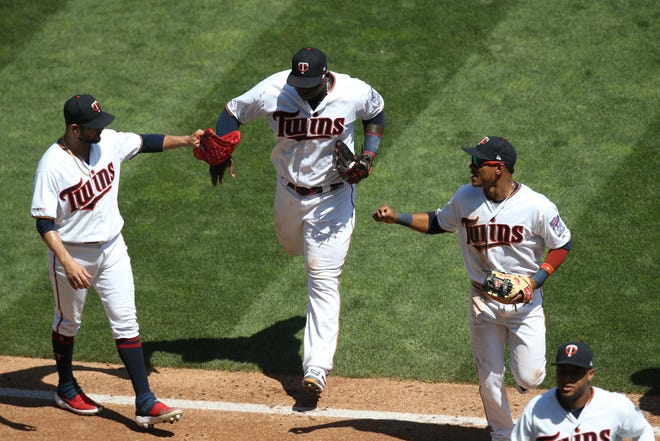 Aug 7: Minnesota Twins starting pitcher Martin Perez (33) celebrates with third baseman Miguel Sano (22) and shortstop Jorge Polanco (11) after completing a triple play during the third inning against the Atlanta Braves at Target Field.