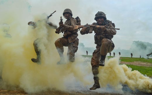 Indian Army recruits shout and jump next to colourful smoke during a training demonstration at the Jak Rifles regimental centre in Jabalpur in Madhya Pradesh state on August 9, 2019.