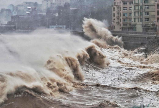 Waves hit a sea wall in front of buildings in Taizhou, China's eastern Zhejiang province on August 9, 2019.