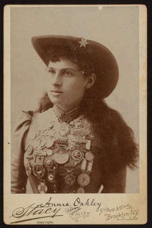 A collectible card of Annie Oakley shows  her shooting medals. The marksman's story is equal parts fact and myth