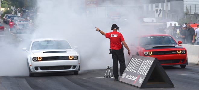 Two Dodge Hellcat Demons drag race against each other.